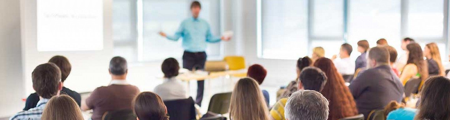 Man speaking in front of a goup of people at a conference
